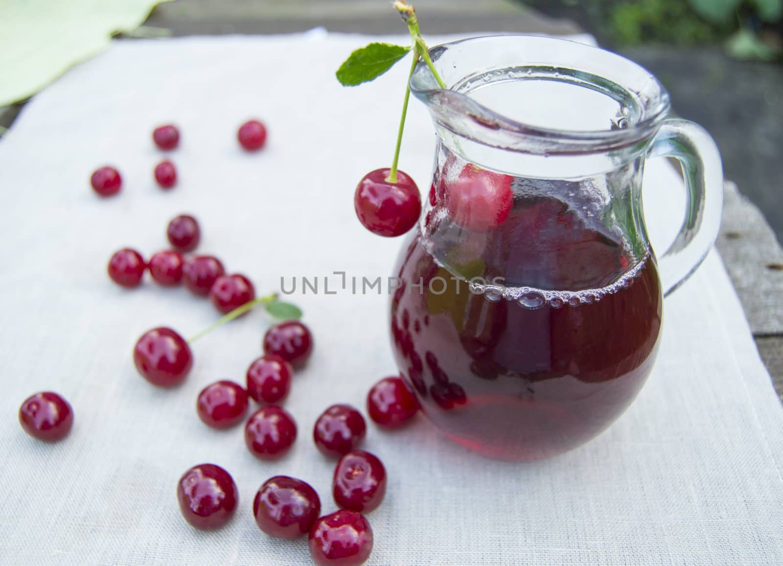 Cold cherry juice in jar and ripe berries, selective focus by claire_lucia