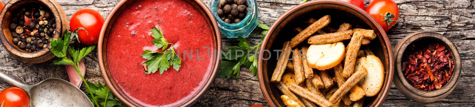 Bowl with fresh tomato soup on wooden table.Long banner