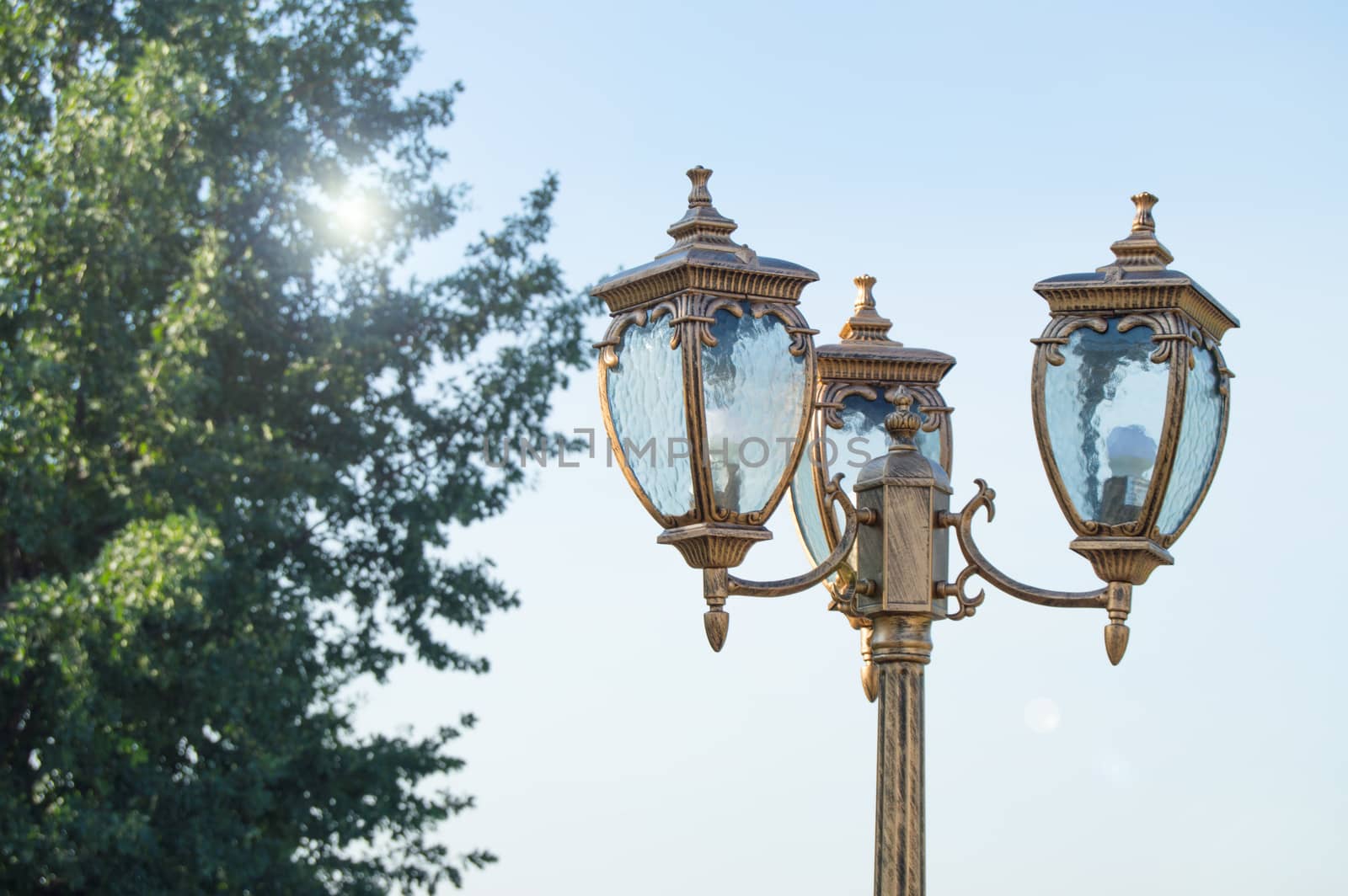 Closeup of a lantern in the Park on the sky background and sun glare by claire_lucia