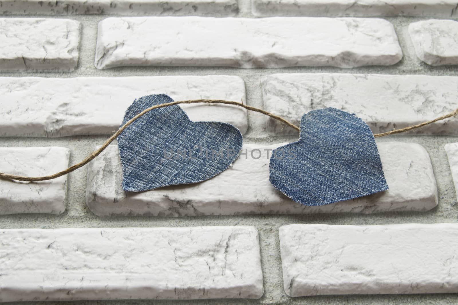 Denim heart Valentine's Day background of white brick wall by claire_lucia