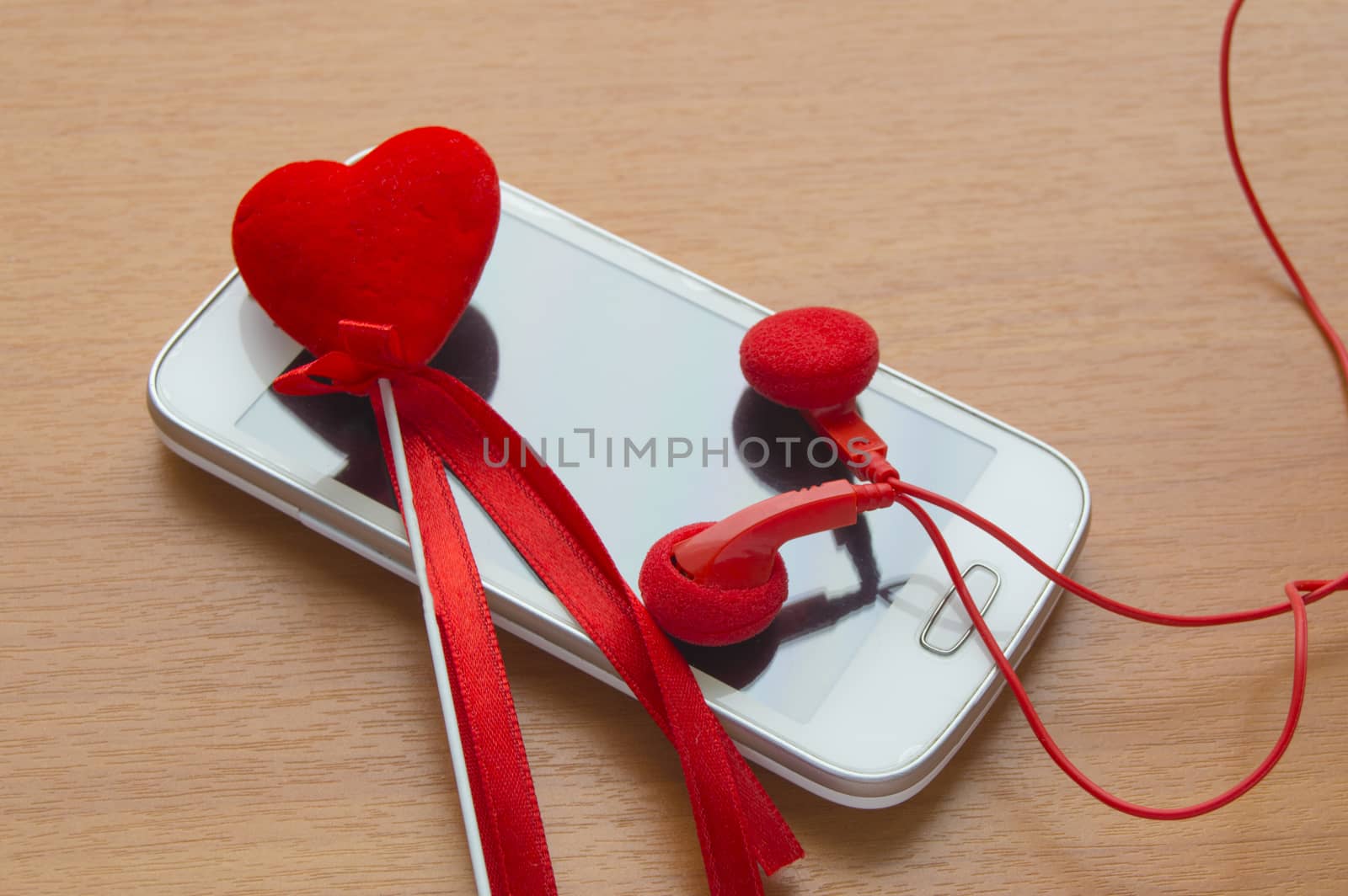 white screen phone with headphones and a red heart, Valentine's Day.