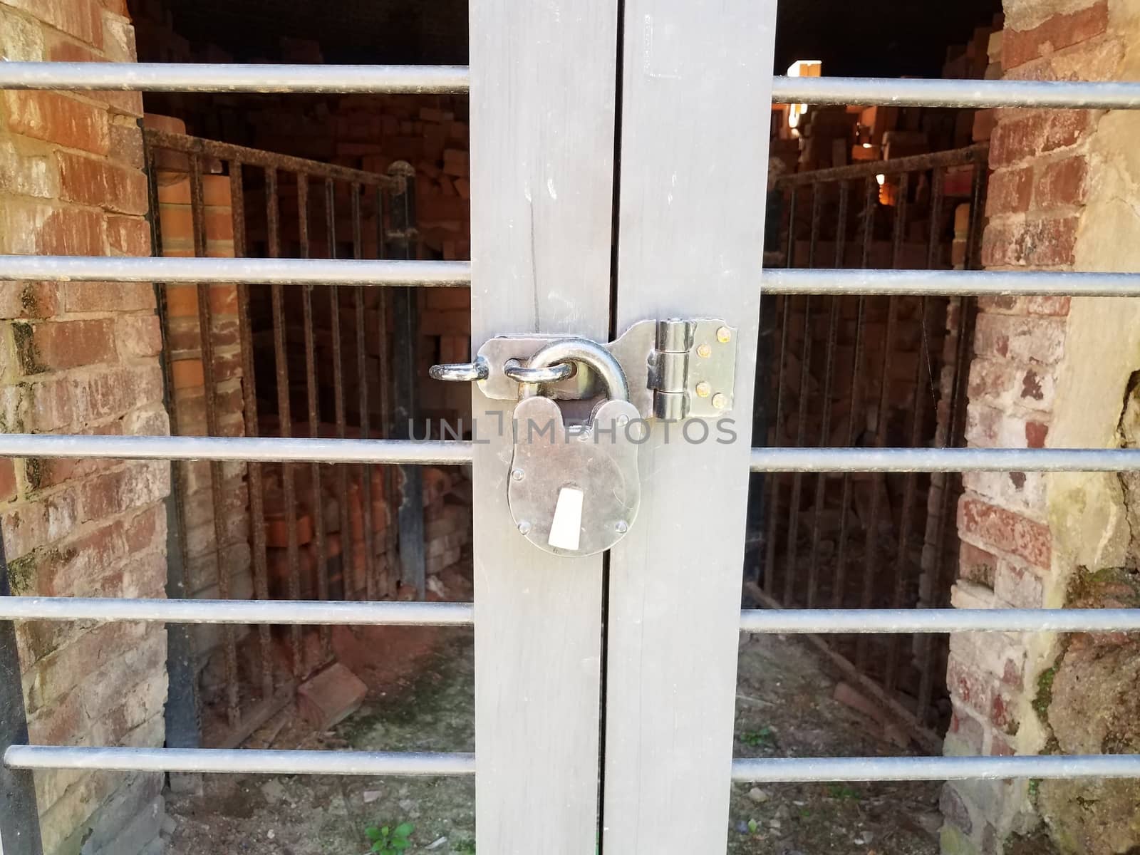 closed metal door with lock and red bricks or masonry