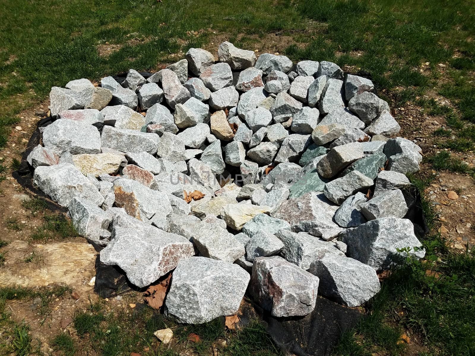 grey rocks or stones or boulders in circular formation on grass or lawn