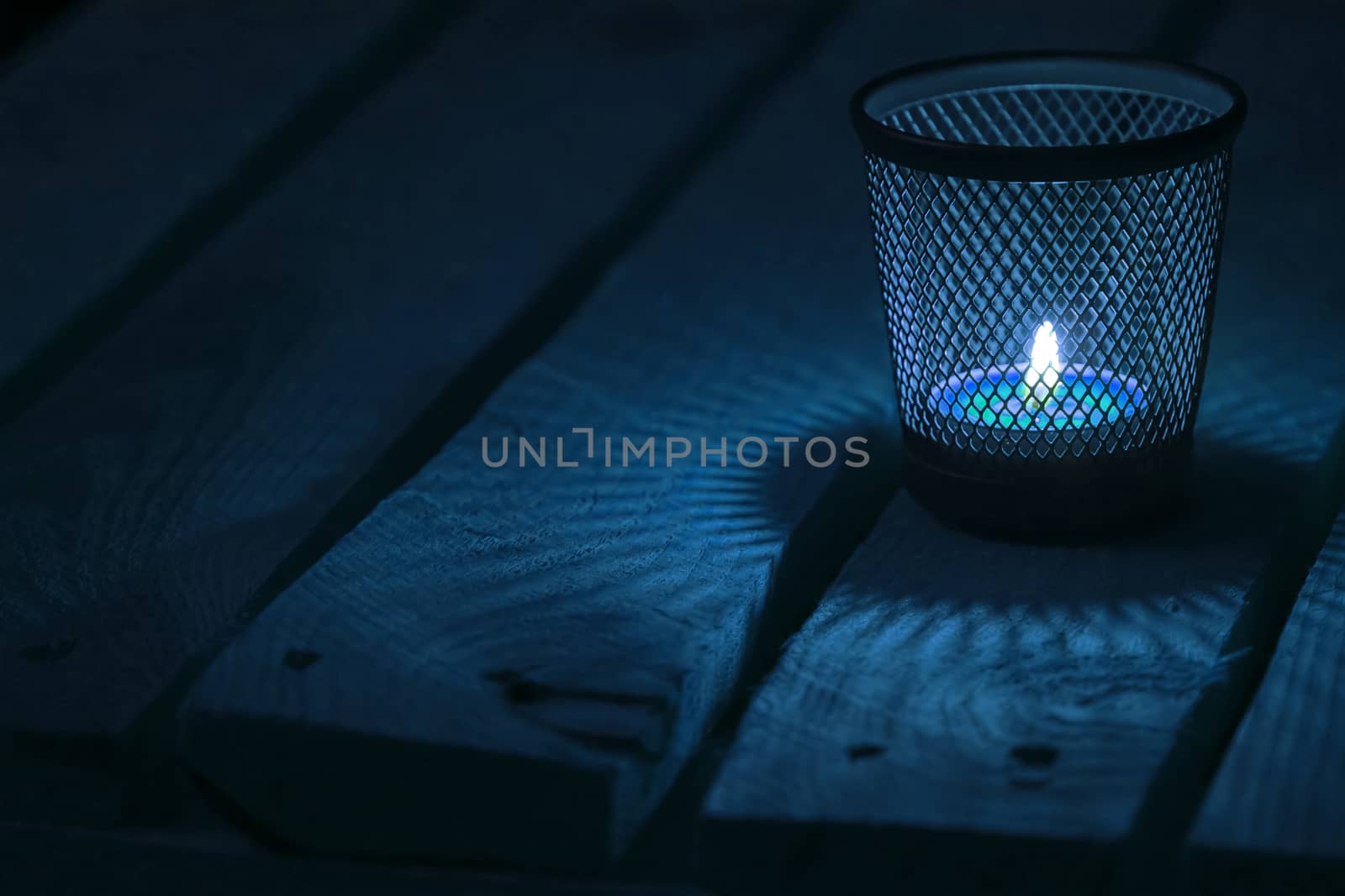 Candle light on natural wooden background. Tealight.  Soft focus.