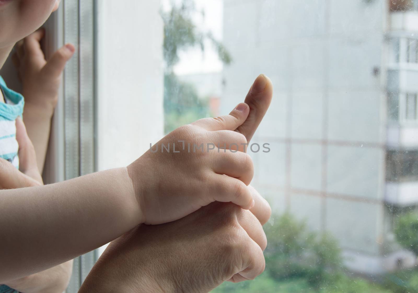 concept of a happy family - an adult holds the hand of a baby.