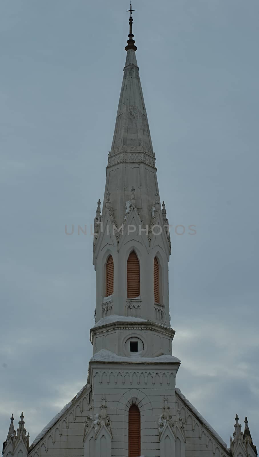 Old white bell tower of a protestant church against cloudy sky by sheriffkule
