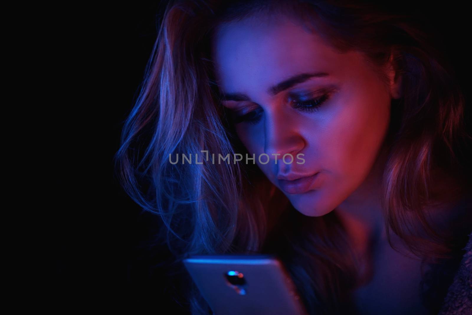 Girl using cellphone at night with neon light - pink and blue by natali_brill