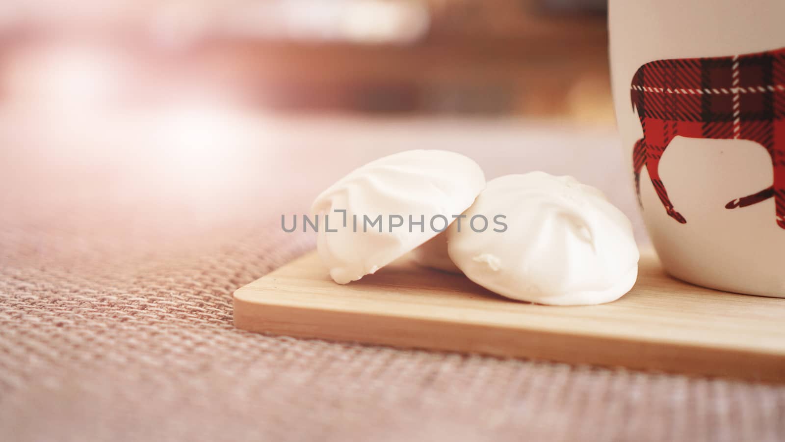 A cup of black tea with white marshmallow. A warm atmosphere - sunny day