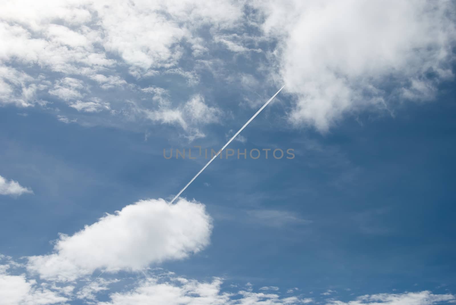 plane crossing the sky from cloud to cloud by Joanastockfoto