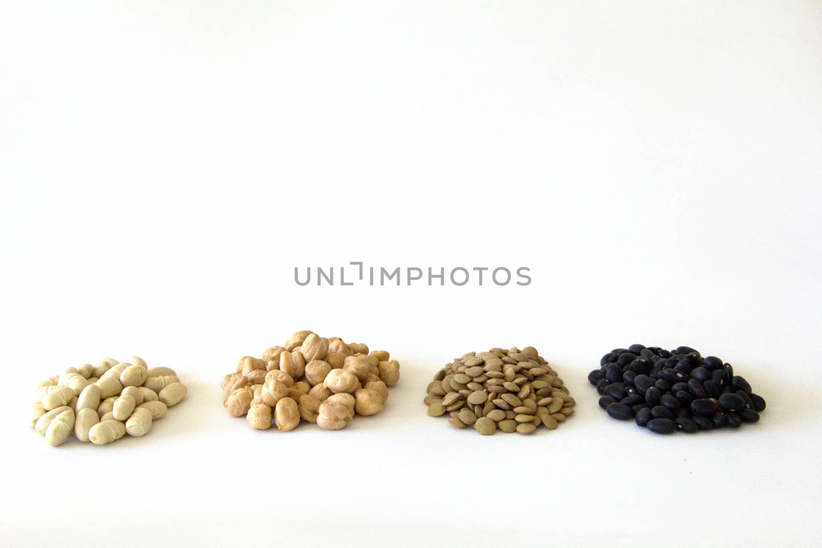 piles of White beans, peas, lentils and black beans with white blackground