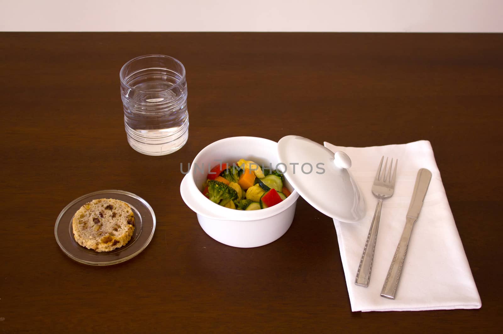 Main course dish, chicken with vegetables, bread, water knife, fork and towel