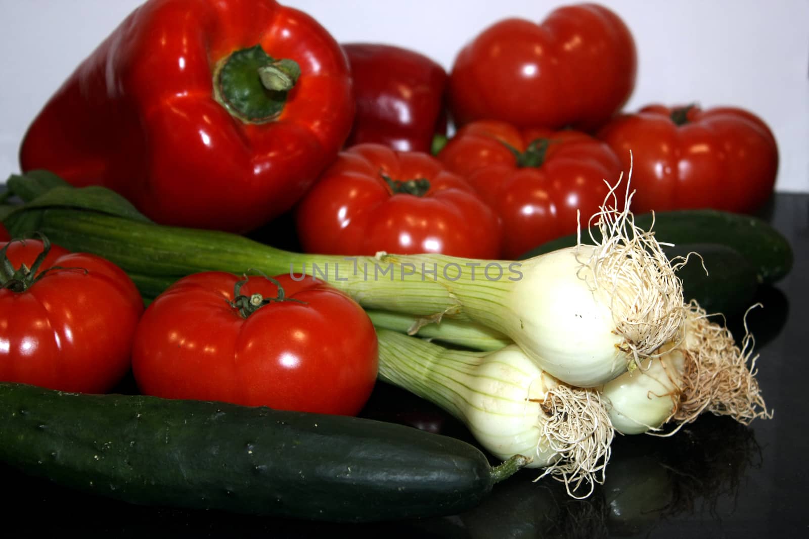 a composition of fresh vegetables peppers, tomatoes, onions, cuc by Joanastockfoto