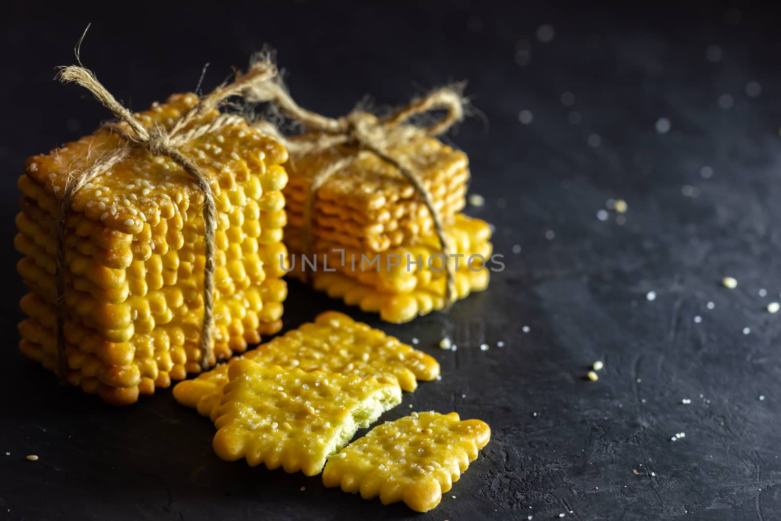 Crackers are tied with hemp rope on table in dark background. by SaitanSainam