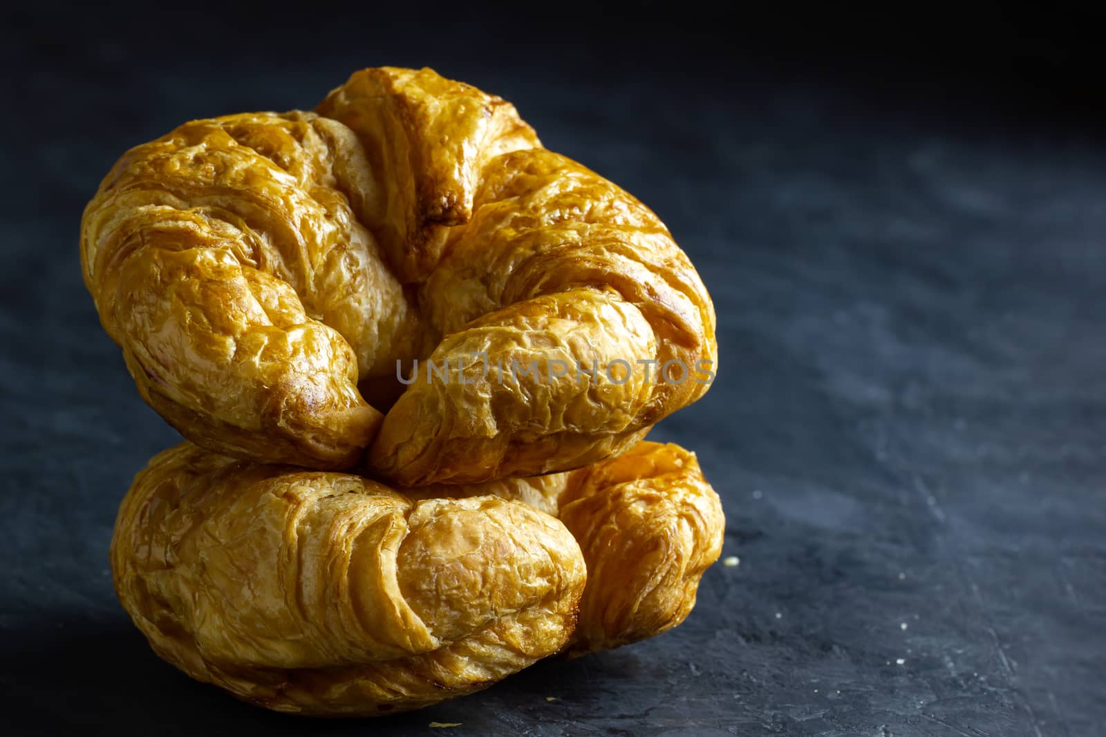 Closeup croissant on table in dark background. Copy space for text.