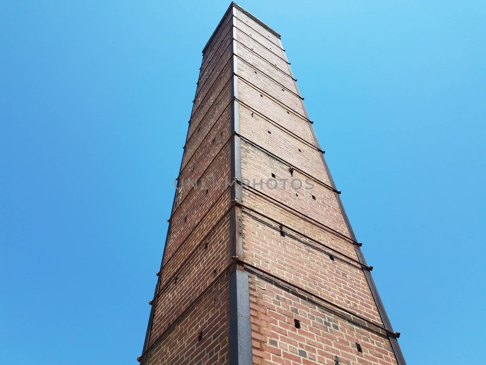 tall red brick chimney or masonry with metal support by stockphotofan1