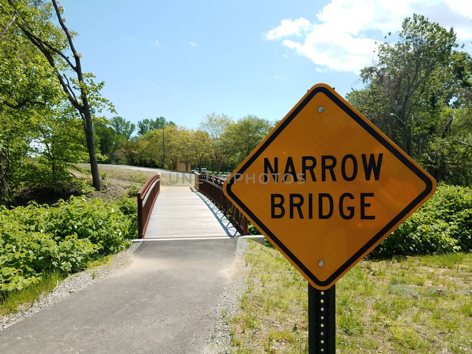 yellow narrow bridge sign and asphalt trail and bridge by stockphotofan1