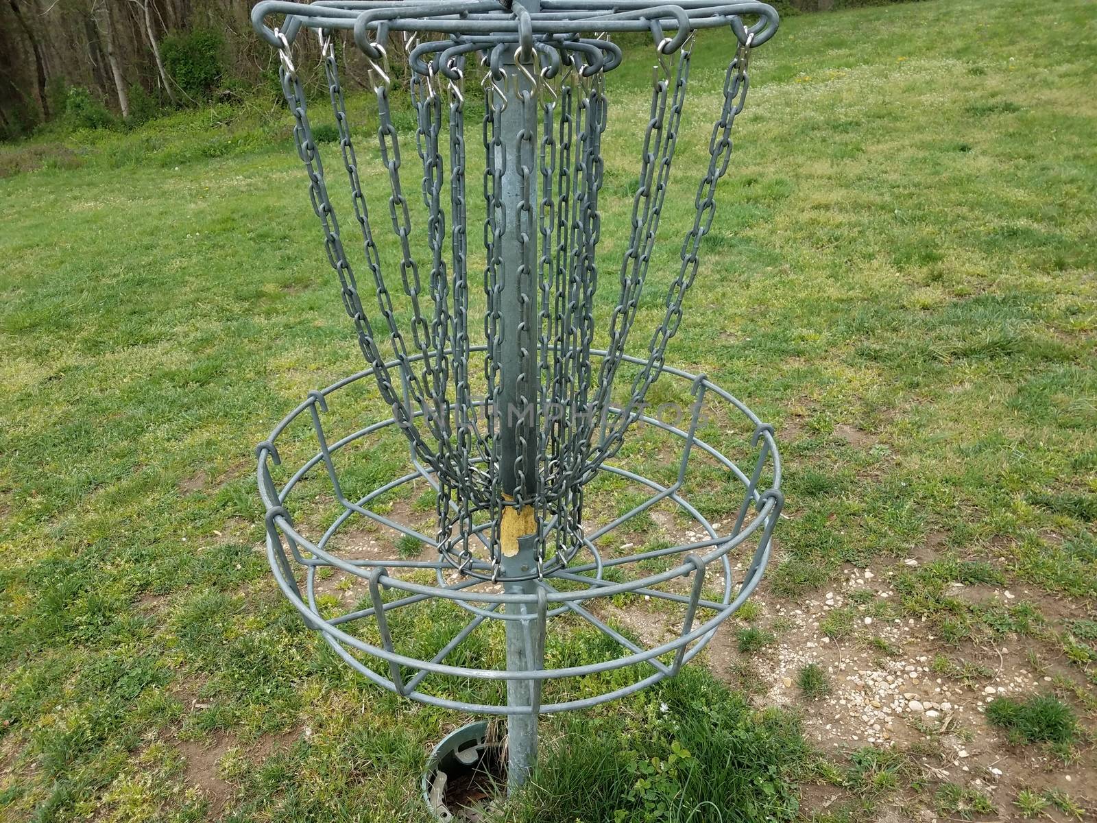 flying disc golf metal chain cage or basket and green grass or lawn