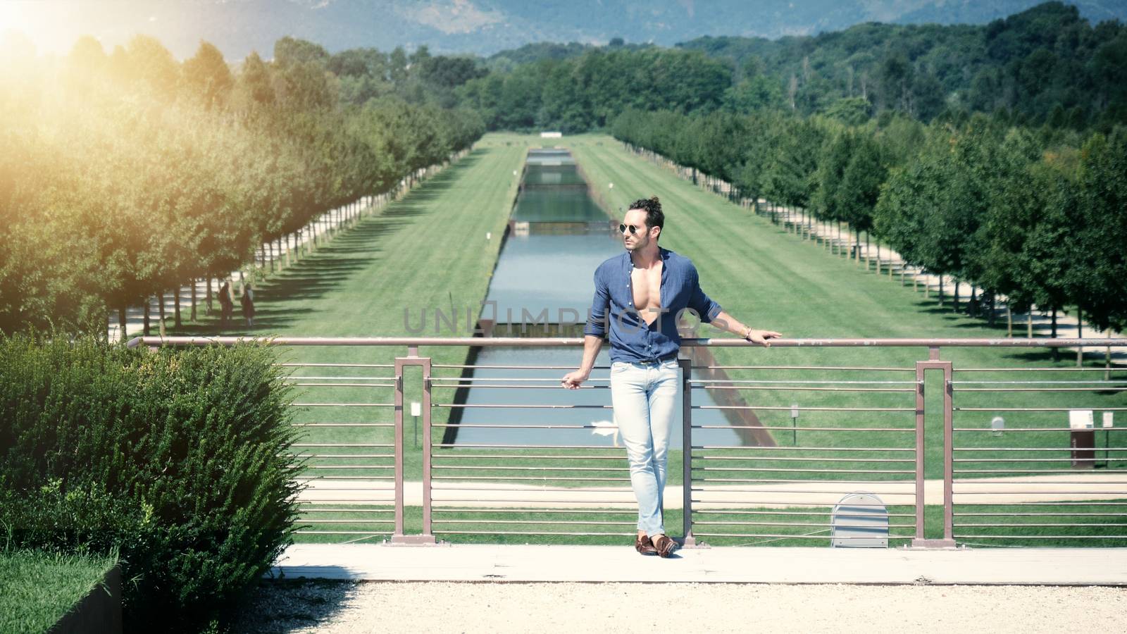 Handsome muscular man posing in European luxury garden in Turin, Italy
