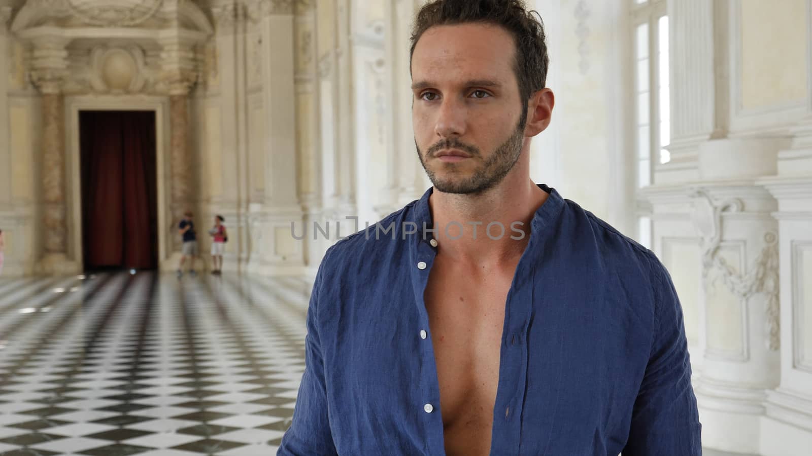 Full Body Shot of a Thoughtful Handsome Young Man, Holding a Guide, Looking Away Inside a Museum
