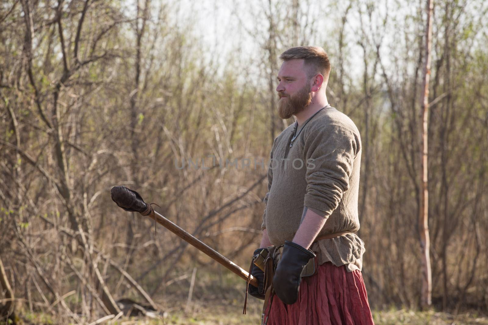 Portrait of Medieval slavic soldier standing outdoors with training spear