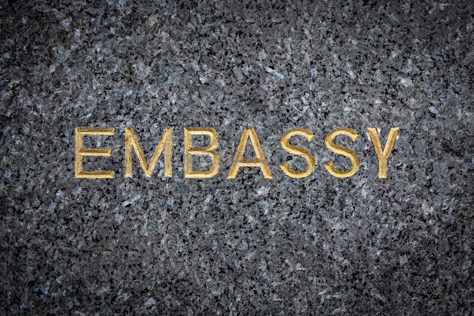A Gold Embossed Embassy Sign On Marble