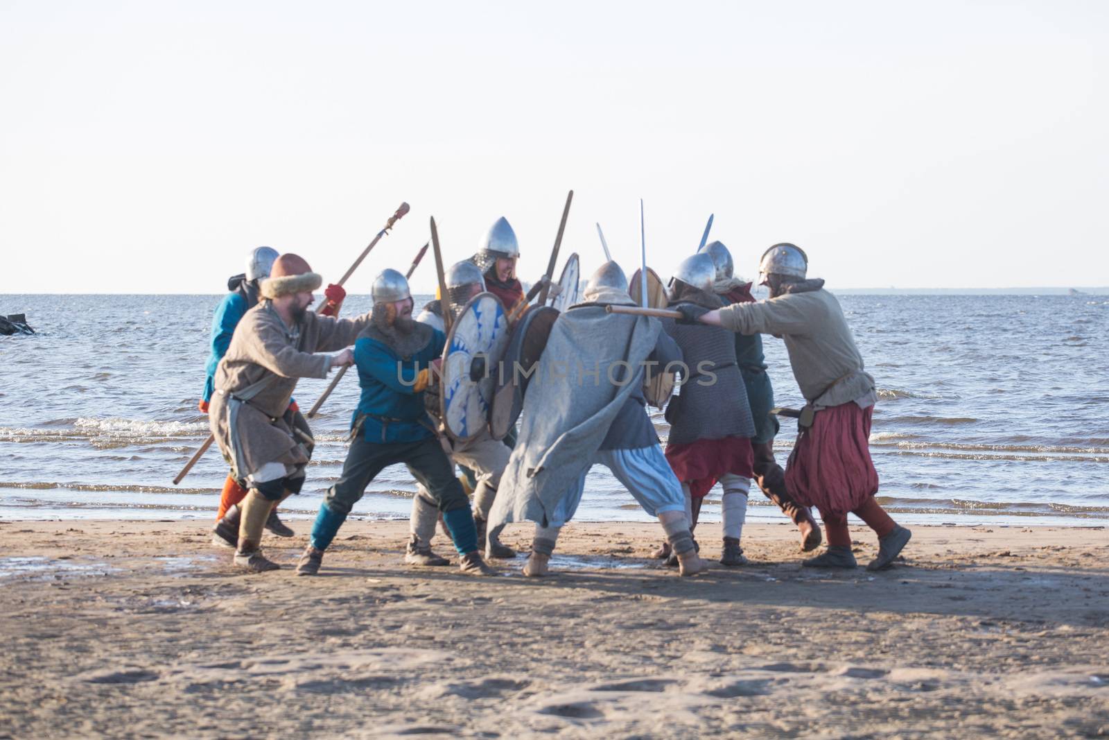 Slavic warriors reenactors with wearpons and shields training fighting outdoors at seaside