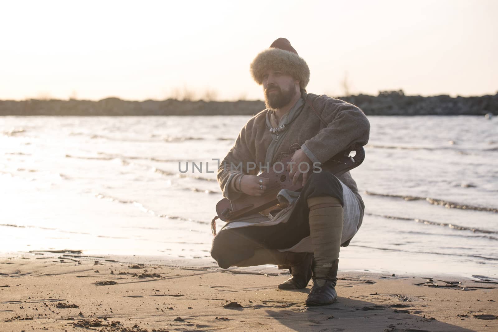 Man reenactor playing gusli by destillat