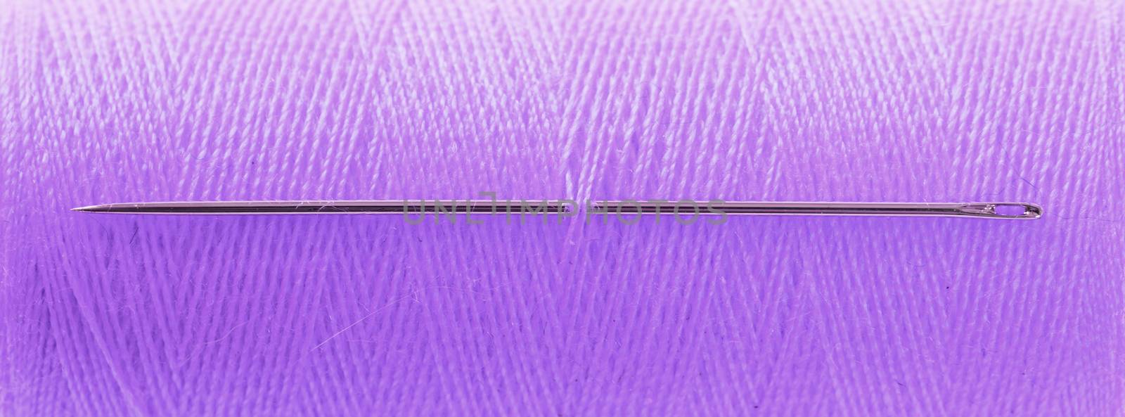 Purple threat with needle, full frame, focus on needle