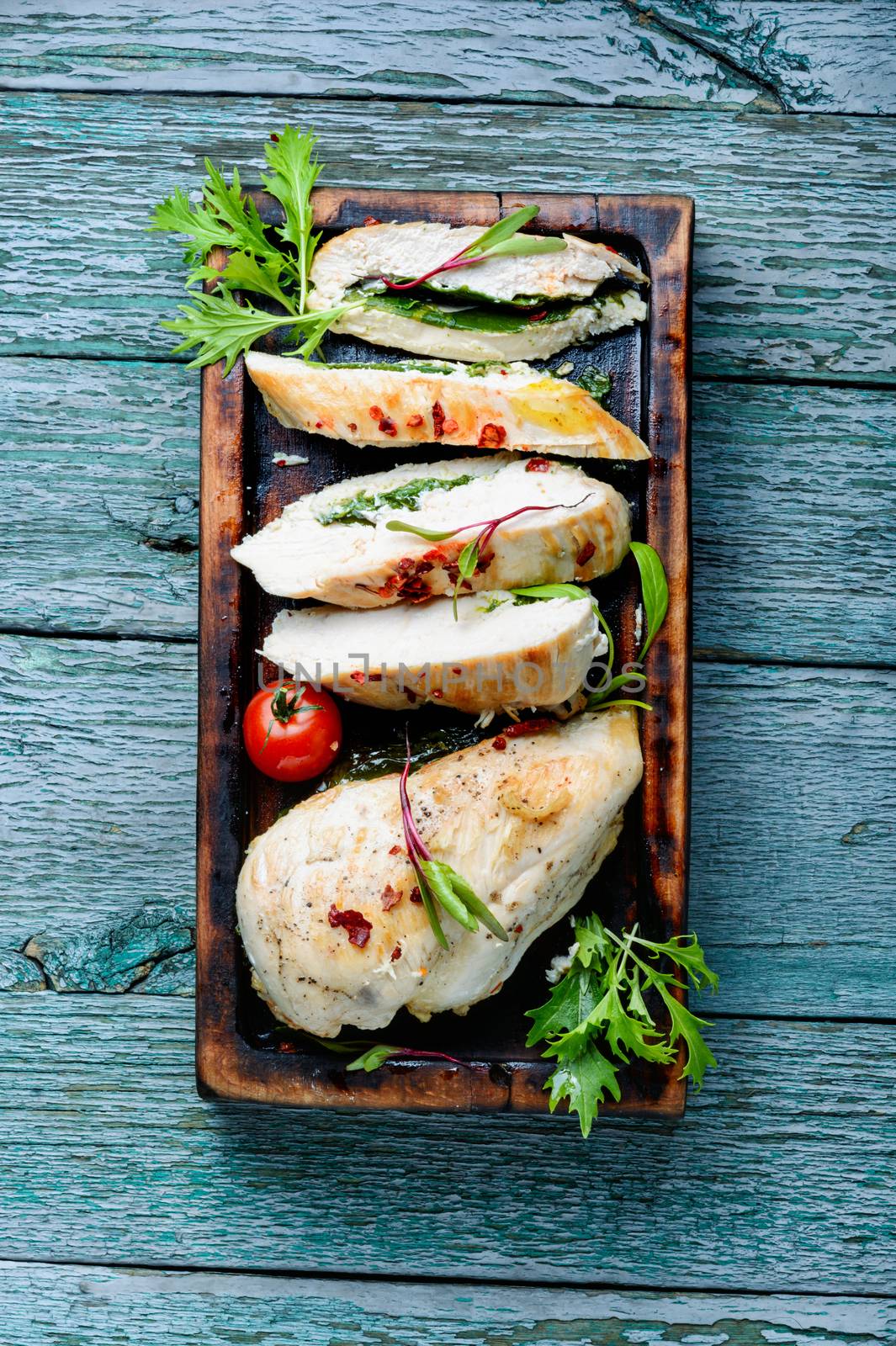 Delicious sliced turkey breast on wooden board.Baked chicken breast stuffed with greens.