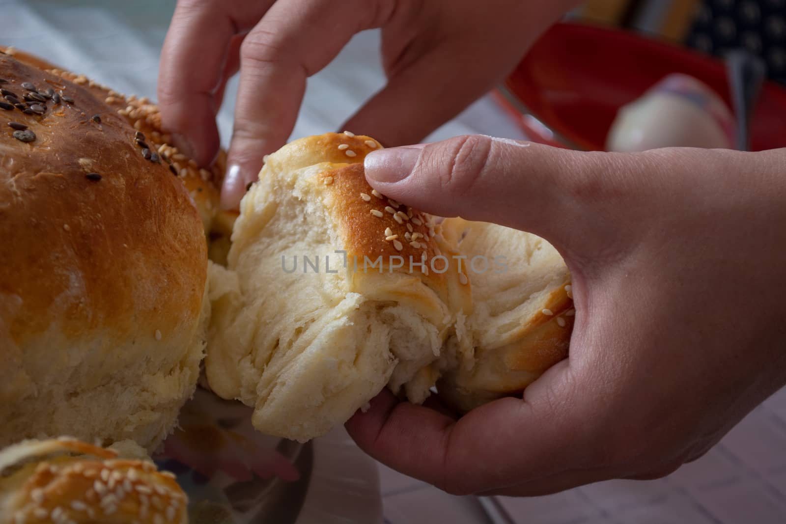 Woman hands breaking bread over the table on ortodox easter