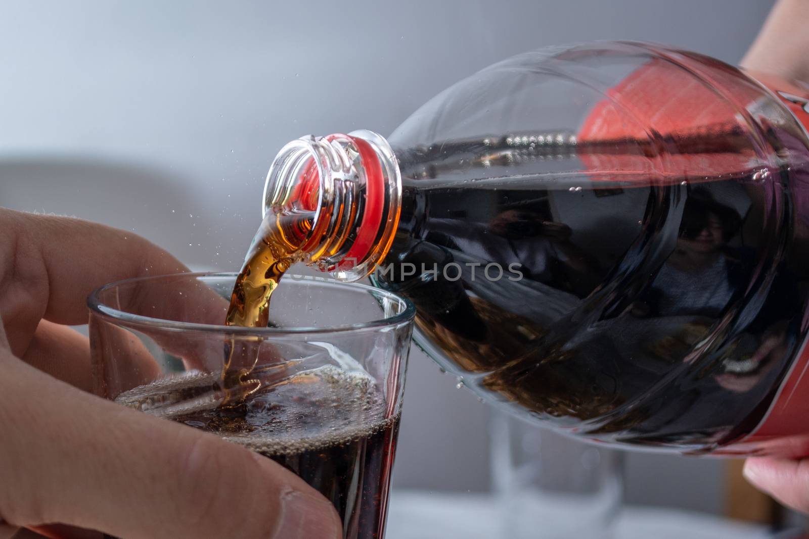 Pouring coke in the glass closeup. Bubbles in the glass