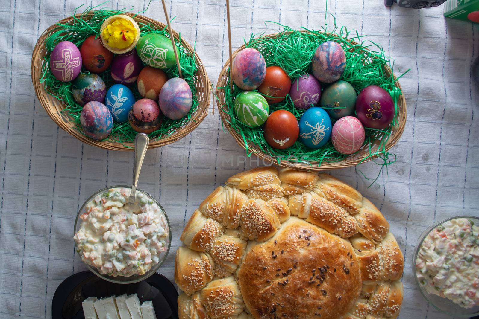 Table ful of food on easter holyday. Colored eggs and bread shoot from upper angle