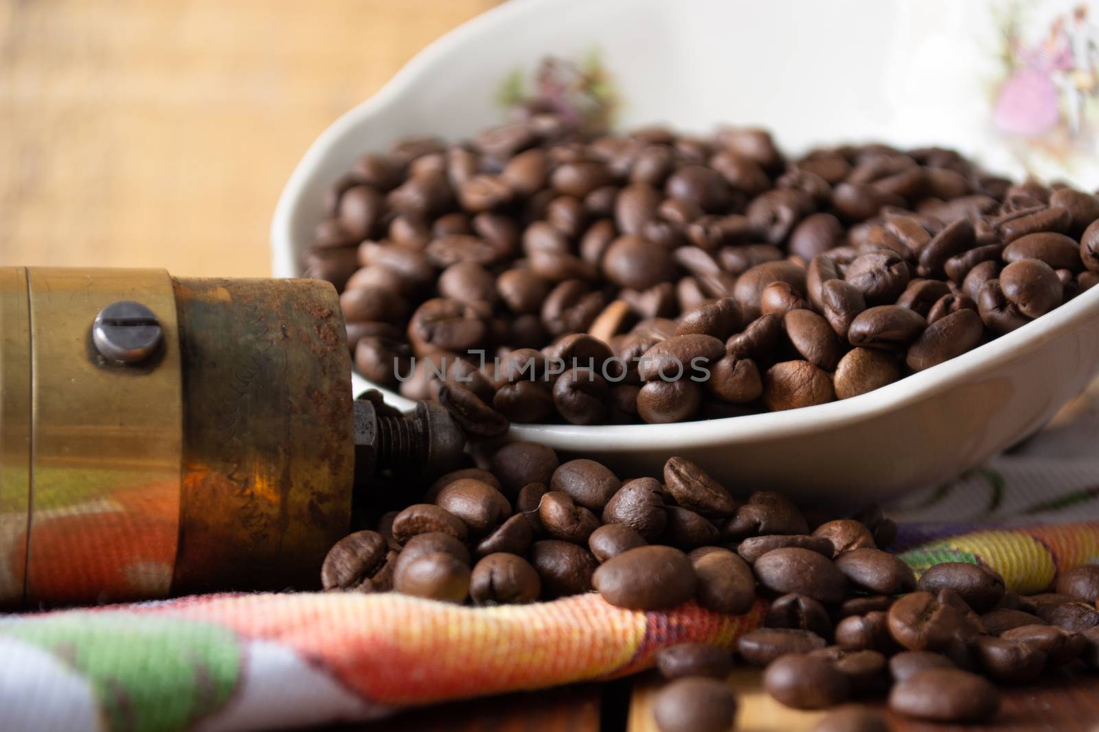 Coffee ready to be milled with old grinder. Coffee is in the table