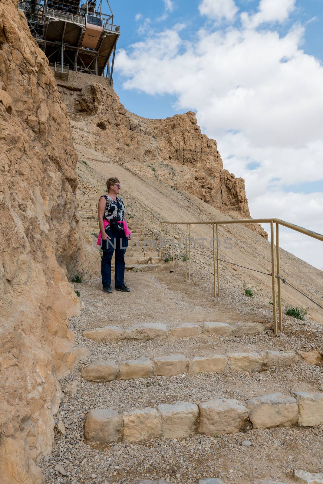 womam walking from masada mountain by compuinfoto