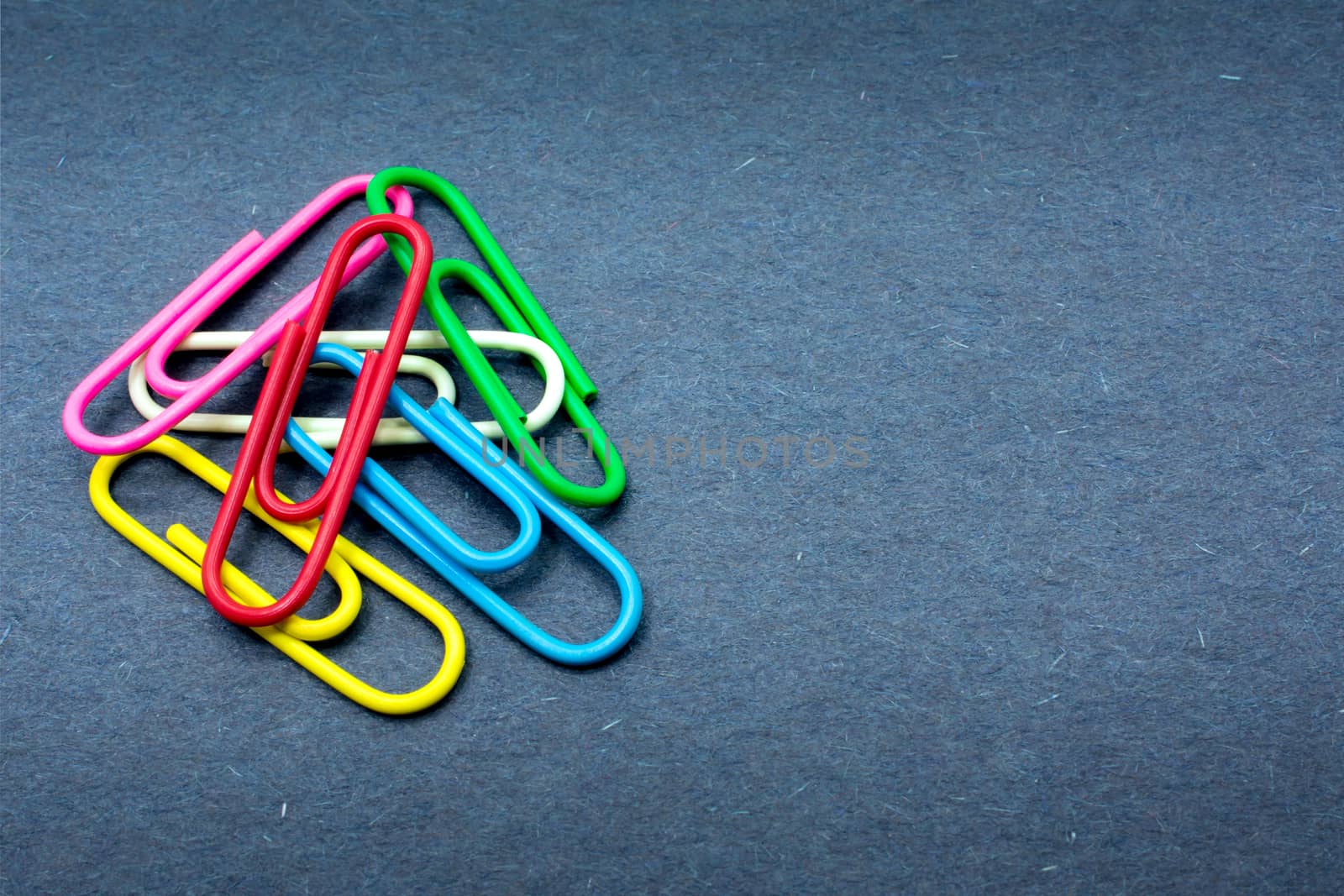 Group of Colorful Paperclips Piled up in the Corner by seika_chujo