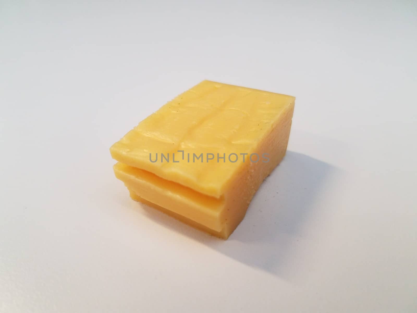 stack of yellow cheese on white surface or table by stockphotofan1