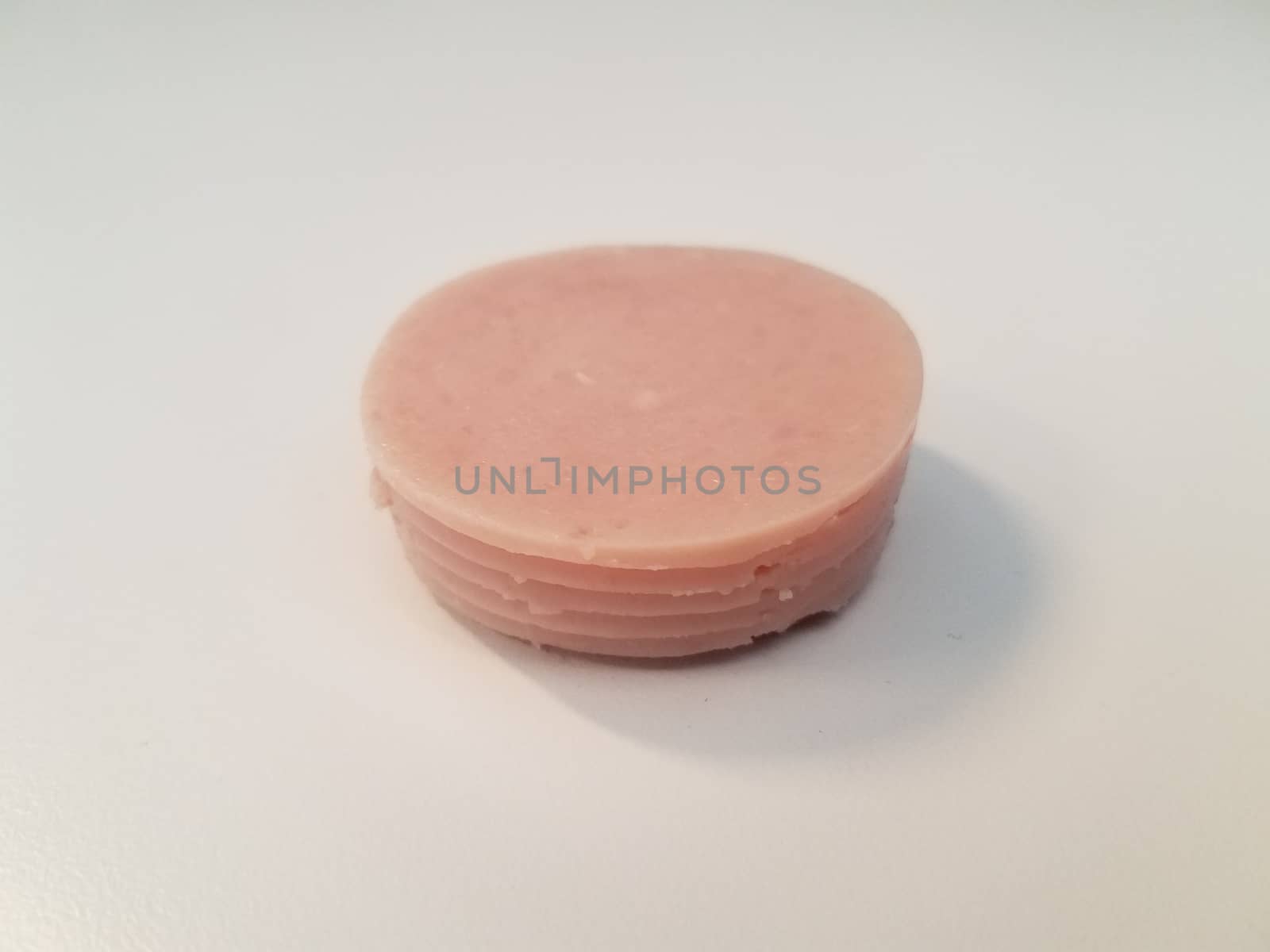 stack of circular pink ham meat on white surface by stockphotofan1