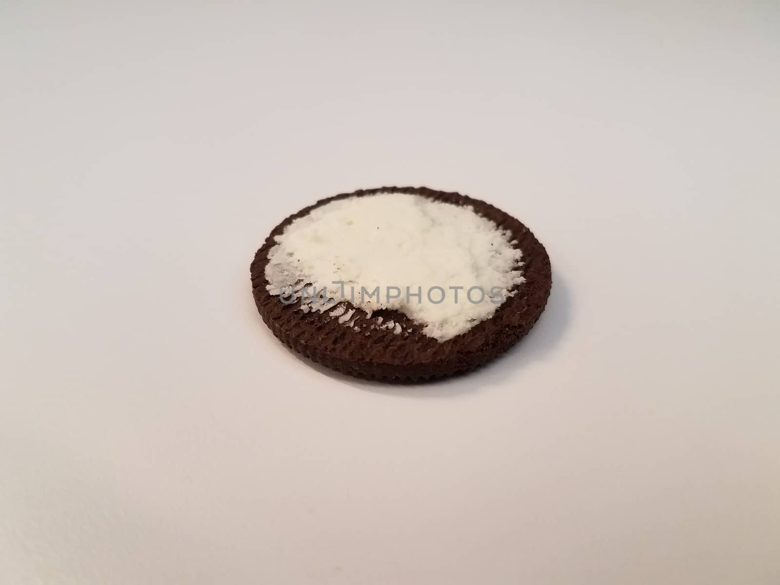 black cookie with white cream filling on white surface or table