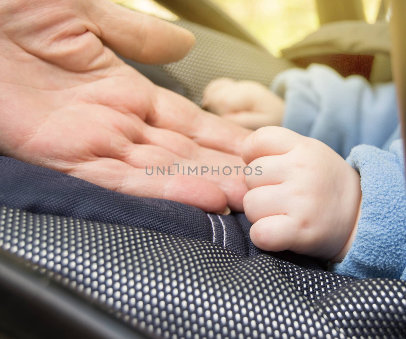 Hand baby and elderly women, grandmothers, selective focus selective focus, baby is in the stroller while walking outdoors, close-up by claire_lucia