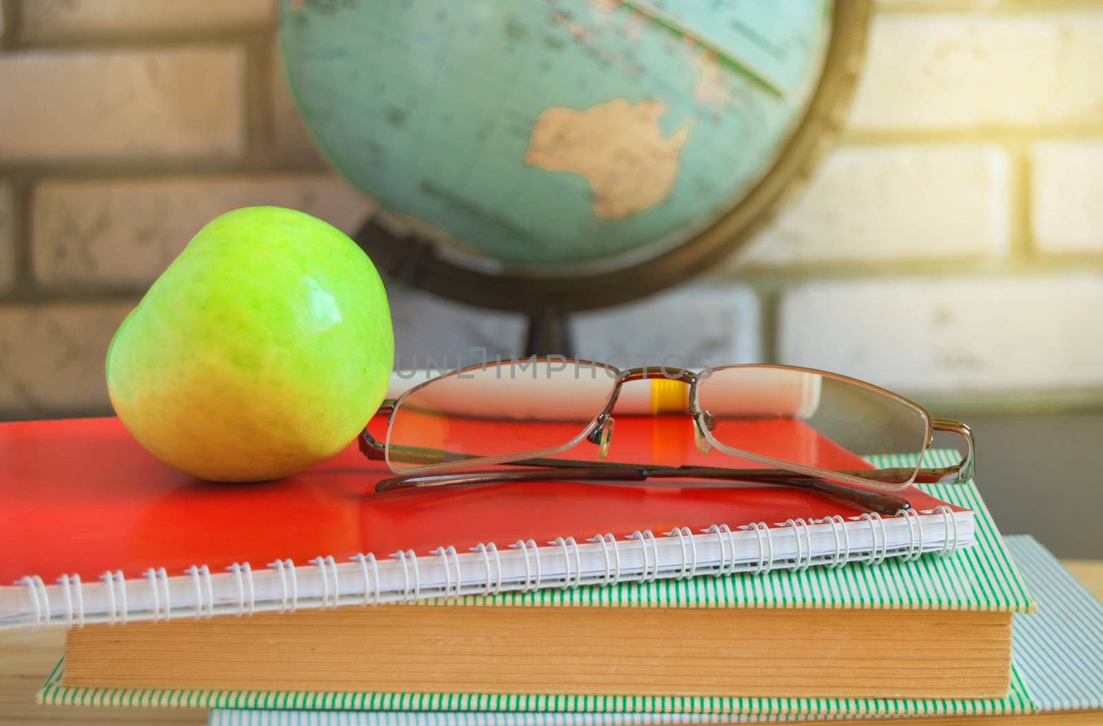 World teacher's Day at school. Still life with books, globe, Apple, glasses, sunlight by claire_lucia