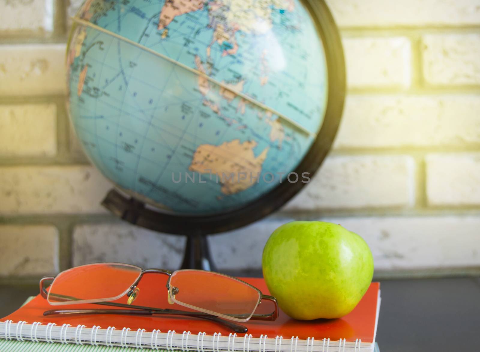 World teacher Day at school. Still life with books, globe, Apple, glasses sunlight.