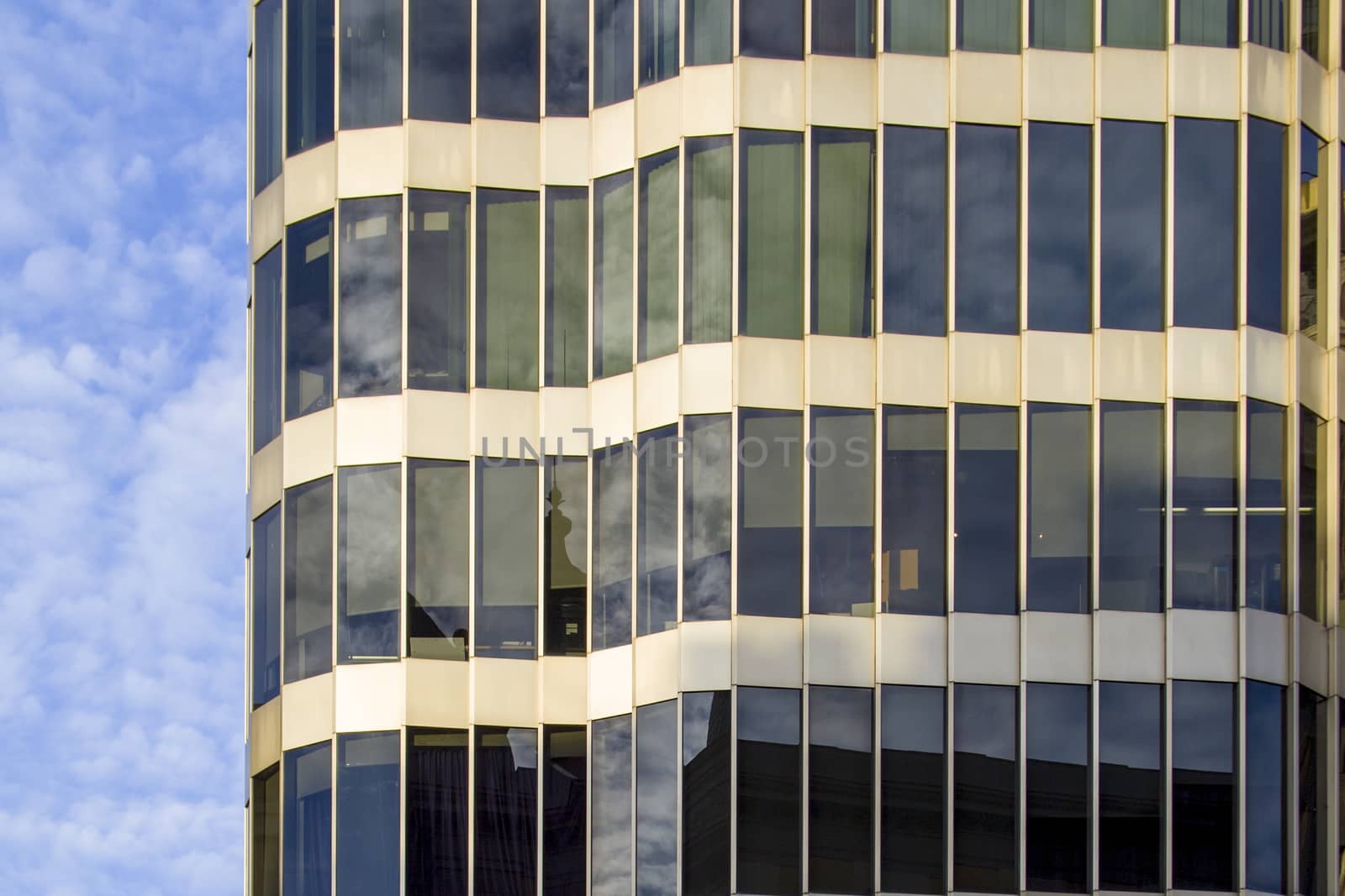 A modern glass and metal building of unusual design with a curved facade.