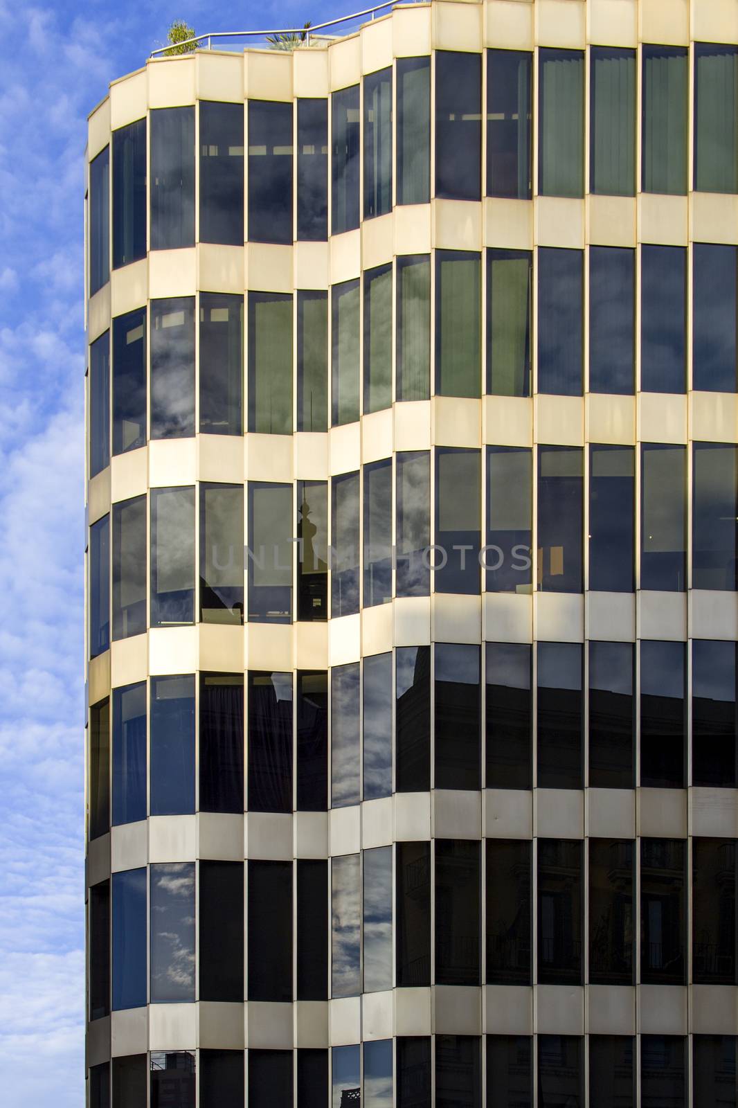 A modern glass and metal building of unusual design with a curved facade.