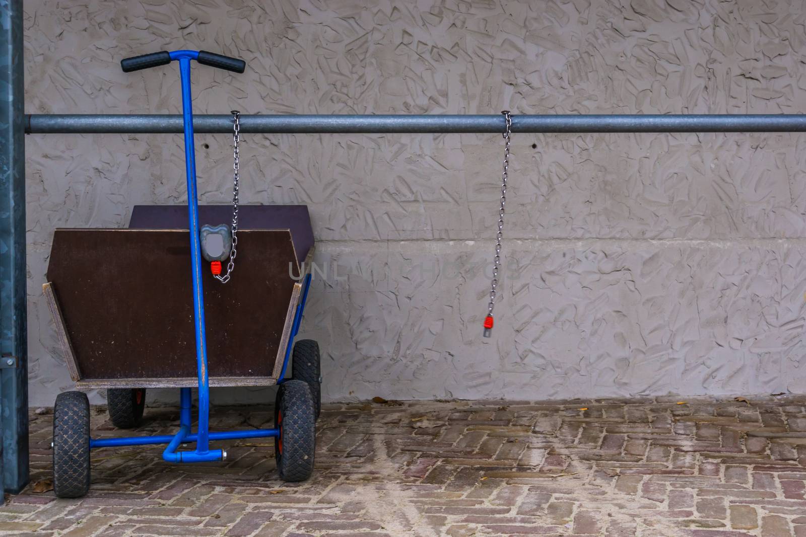 pulling trolley for luggage and kids, locked and leashed on a metal bar, outdoor transportation