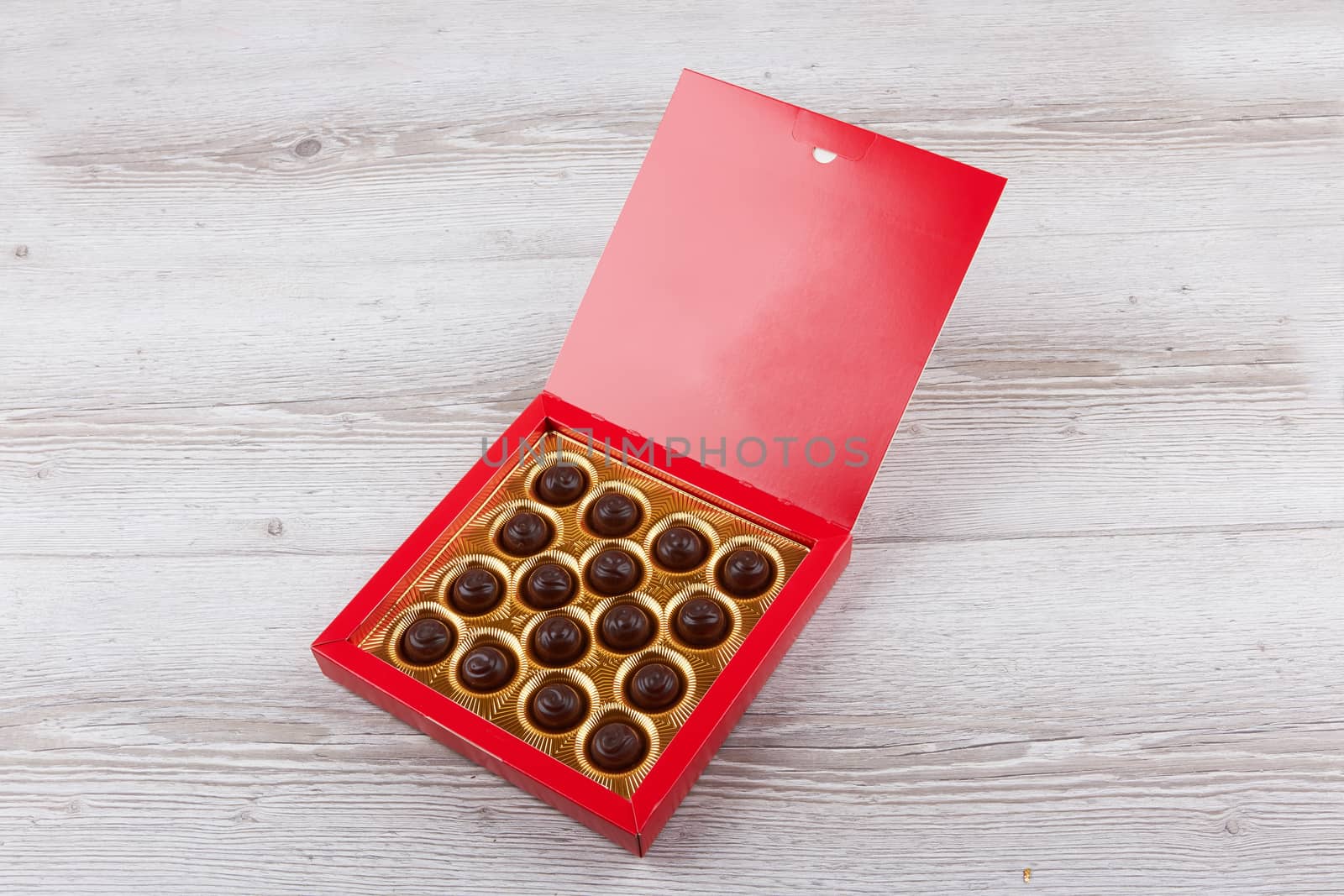 chocolate candy in a box isolated on wooden background