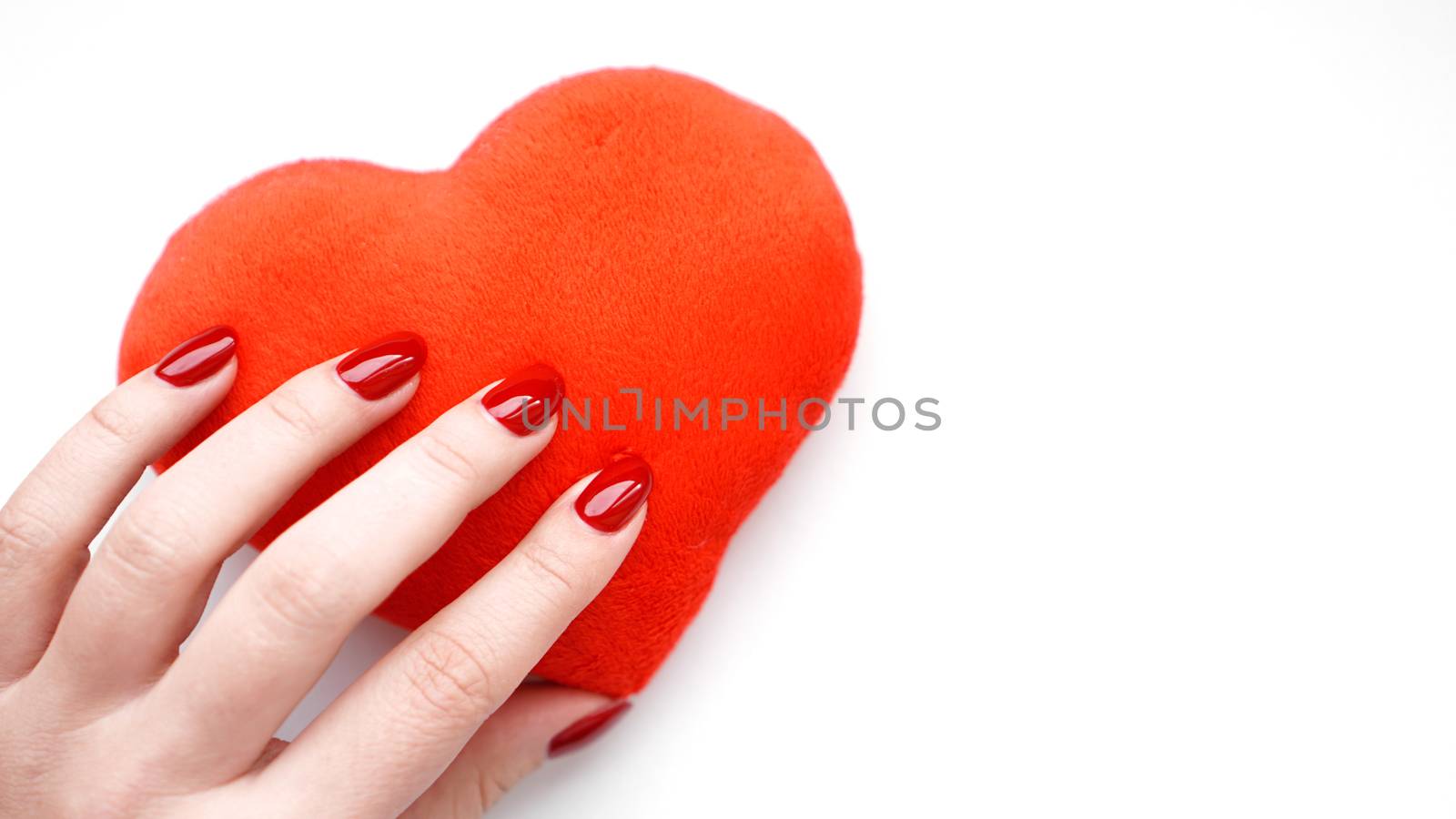 Female hand with red heart isolated on white background. Concept manicure by natali_brill