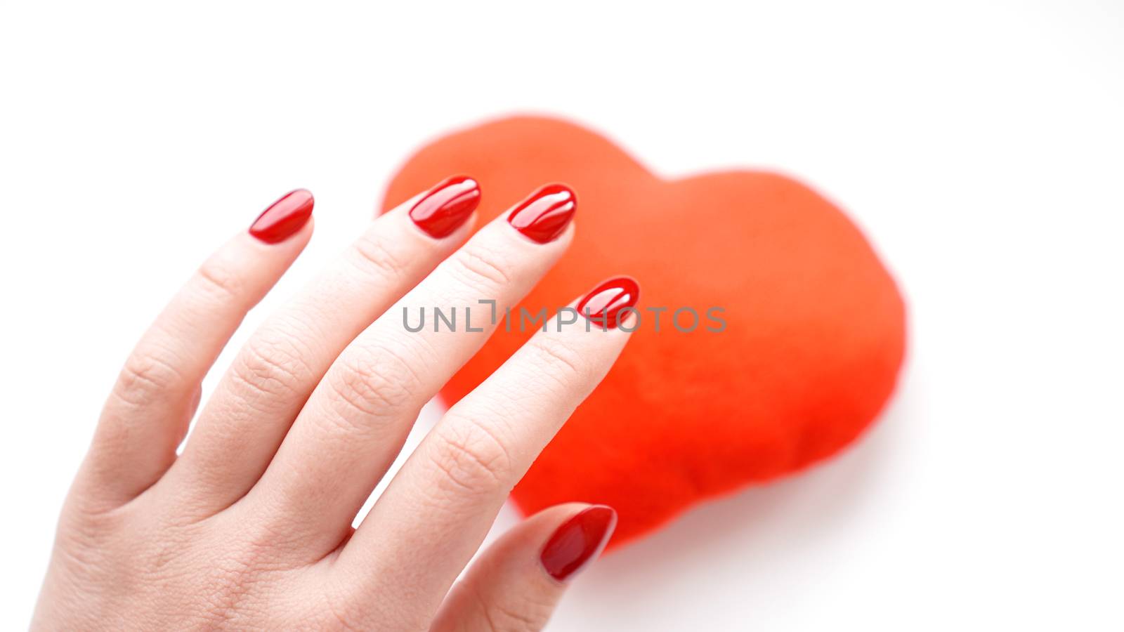 Female hand with red heart isolated on white background. Concept manicure by natali_brill