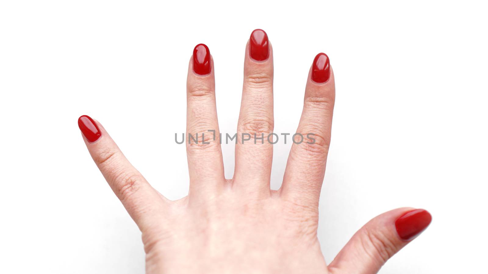 Beautiful female hand with fresh red manicure and nail isolated on white background