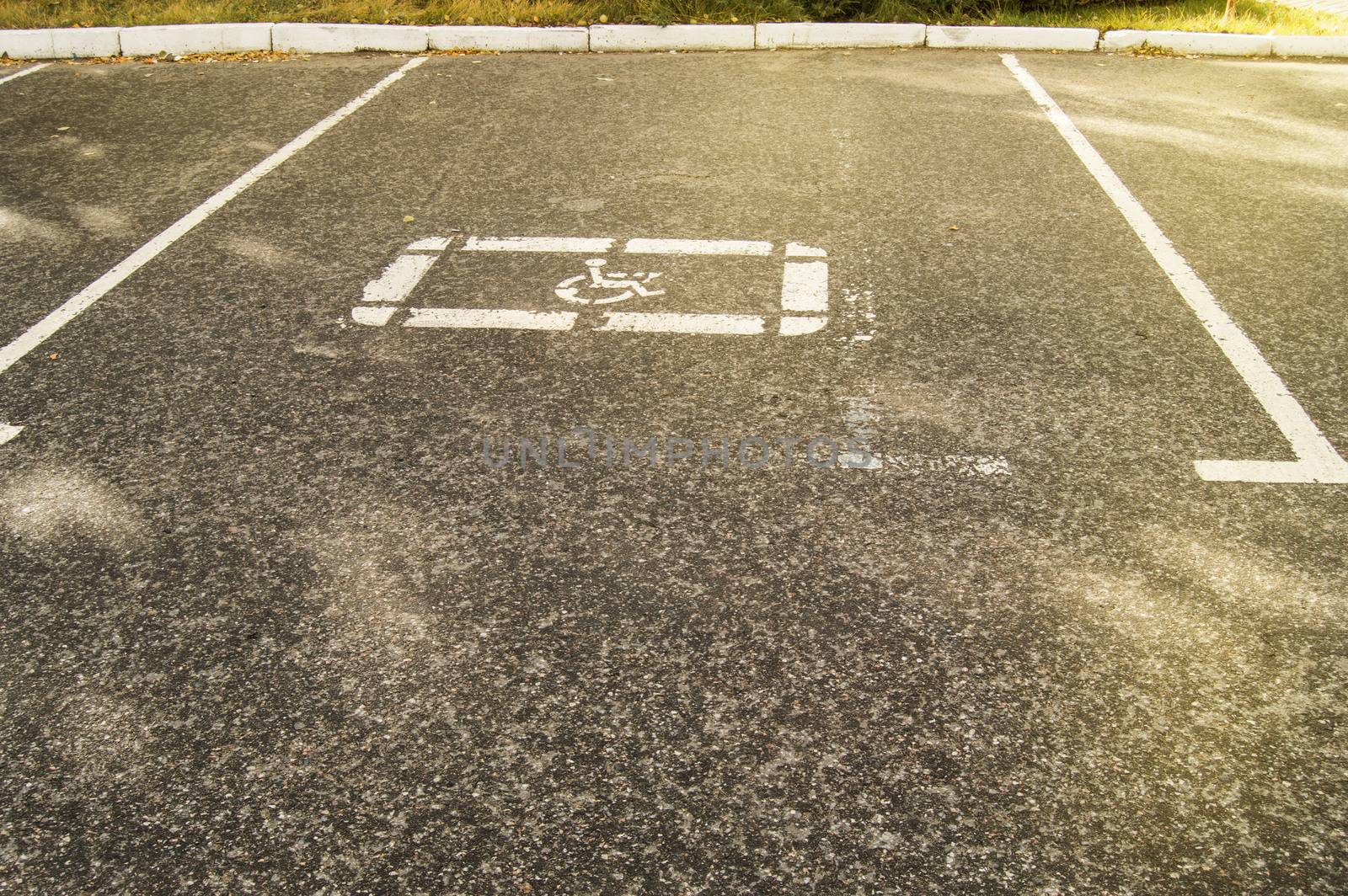 Parking sign for disabled people painted on the asphalt in an empty Parking lot, sunlight.