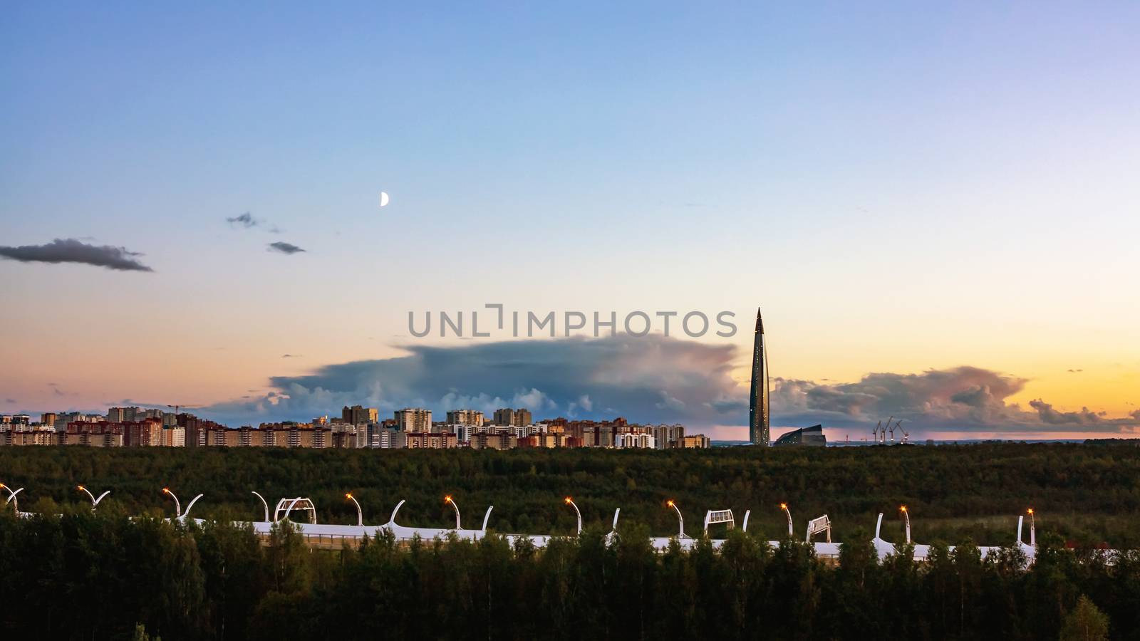 Evening cityscape. View of the Lakhta Center tower in St. Petersburg in the sunset with clouds and moon.